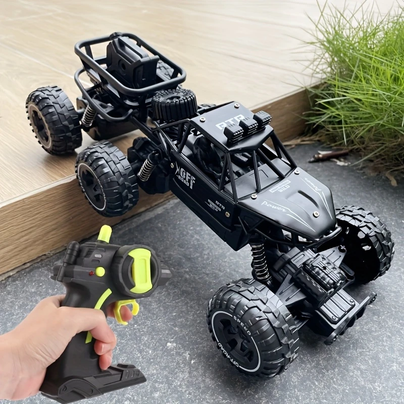 Black RC Rock Crawler with remote control. Toy car with oversized tires and a detailed chassis.